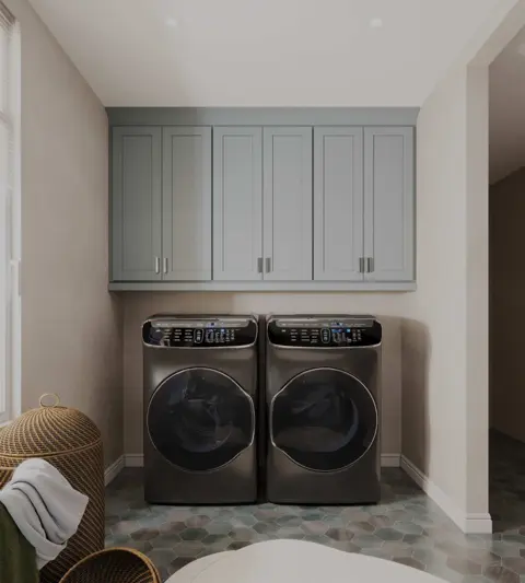 Laundry room with pale gray-green wall cabinets above a washer and dryer