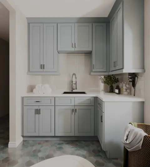 Laundry room with pale gray wall and base cabinets around a small sink